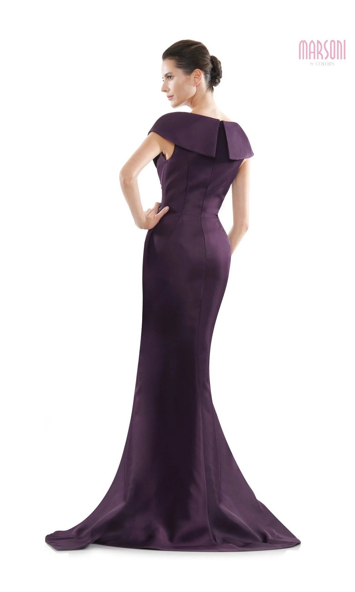A woman models the Marsoni MV1086, a fitted, floor-length dark purple trumpet gown with a draped back, standing against a white background.
